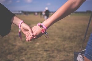 A photograph of two women holding hands